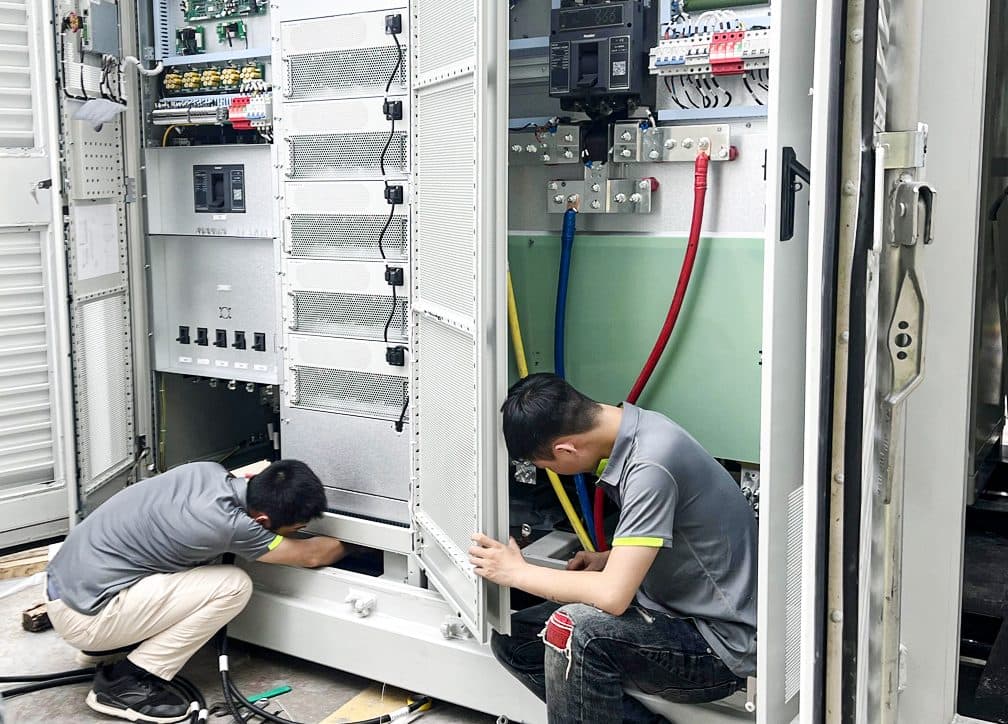 Technicians commissioning a containerized battery energy storage system